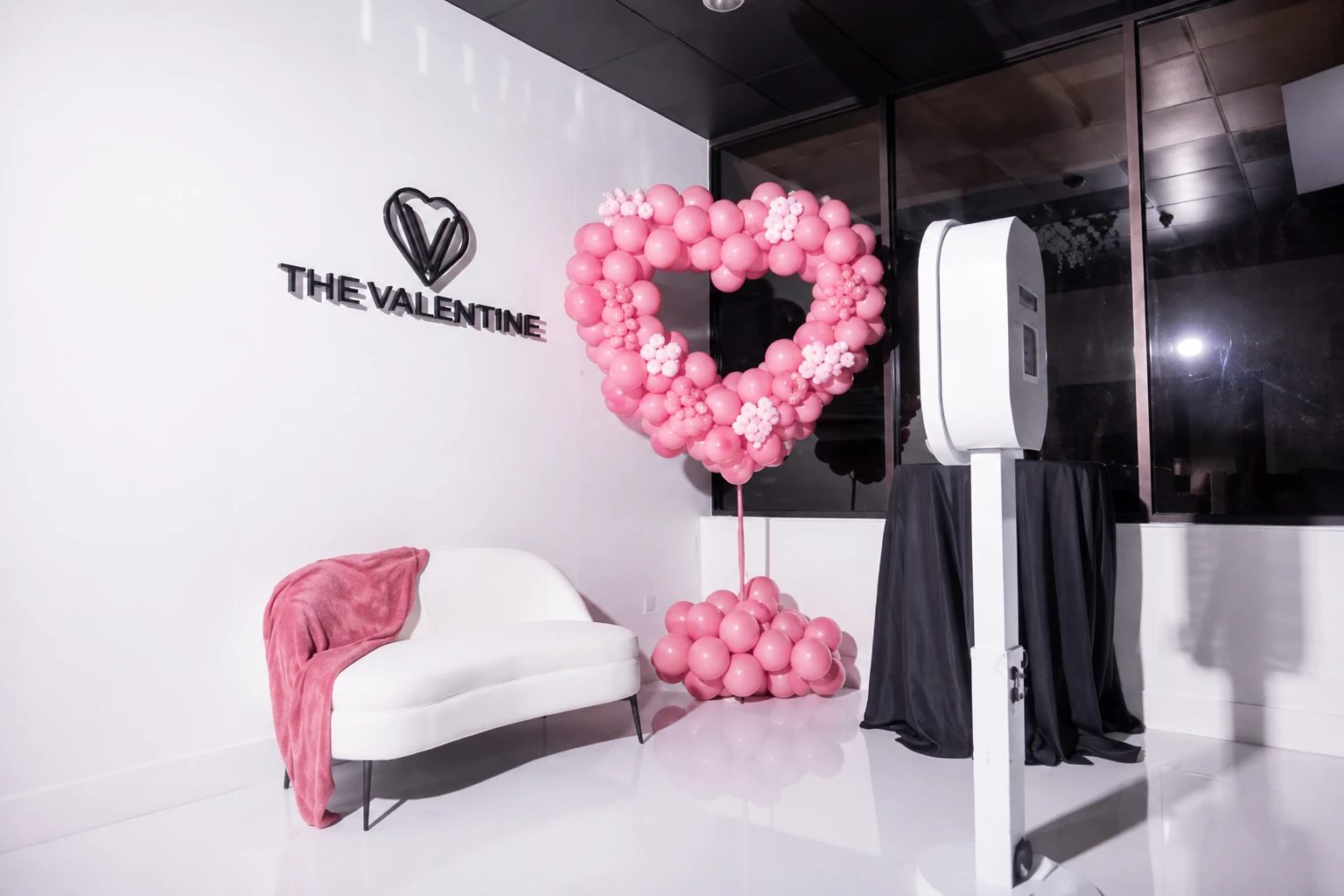 The Valentine Orlando wedding venue with pink heart balloon decor, white lounge seating, and elegant event setup